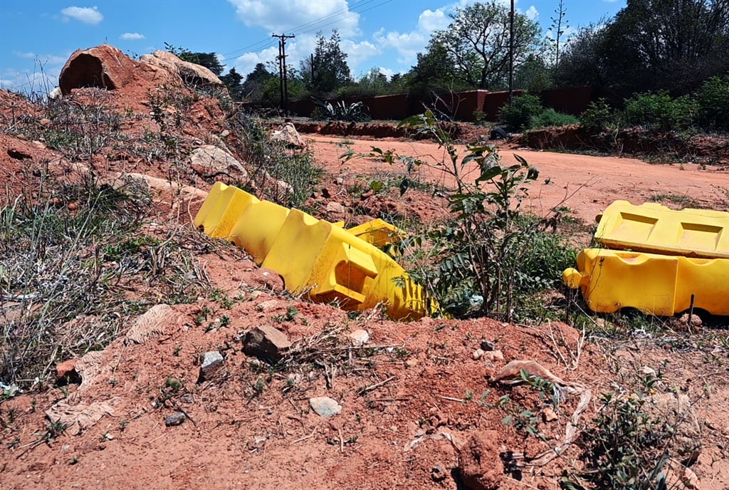 A pile of large stones and plastic roadblocks