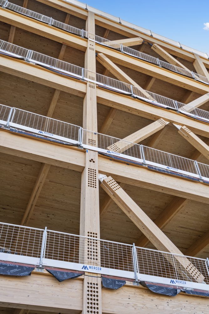 Close up of a multi -storey wooden building that shows modern design elements and safety railings.