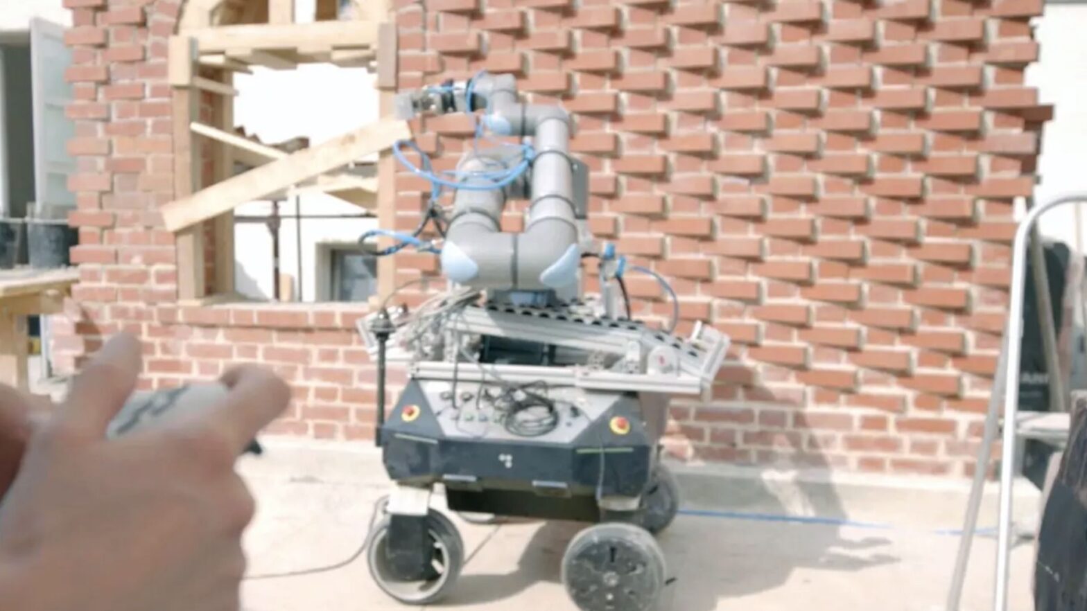 German robot works on construction sites and helps the man to build wall