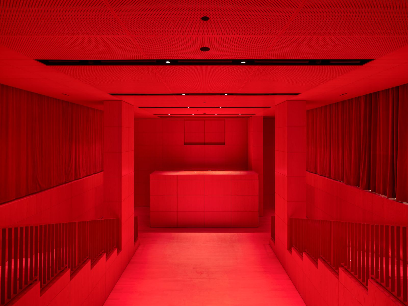 The auditorium is lined in red lacquered wooden panels.