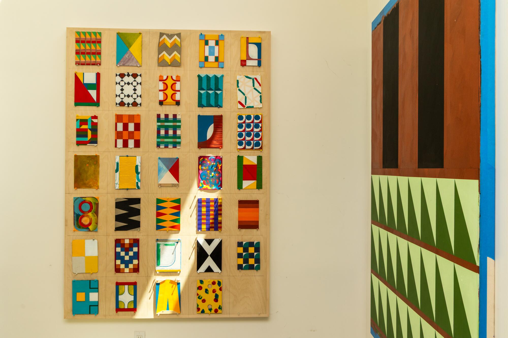 Geometrically painted canvases hang in the ADU.
