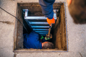 Workers enter the underground well to make repairs